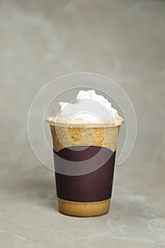 Iced Blended Hazelnut Latte coffee served in disposable cup isolated on grey background top view of cafe dessert