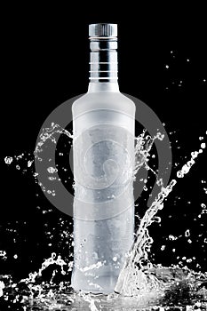Iced bottle of vodka splash on a black
