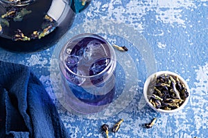 Iced butterfly pea flower tea, glass of blue anchan and dry clitoria ternatea