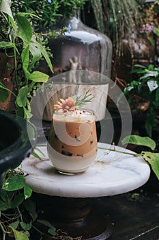 Iced caramel latte coffee with syrup and whipped cream decorate with flower.