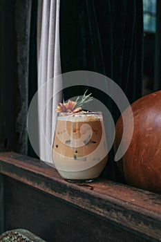 Iced caramel latte coffee with syrup and whipped cream decorate with flower.