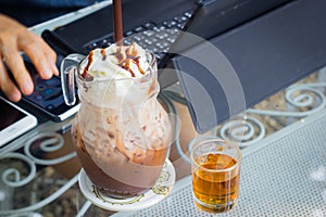 Iced chocolate milk with whip cream on the background of blurre