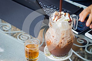 Iced chocolate milk with whip cream on the background of blurre