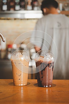 Iced chocolate and iced mocha on table with blurred back view of baretta