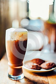 Iced cocoa drink  with whipped cream and Brownie cookies on wood table