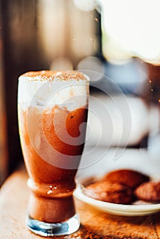 Iced cocoa drink  with whipped cream and Brownie cookies on wood table