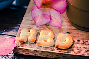 iced coffee and biscuit alphabet spell HBD with rice field background