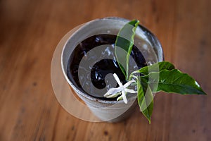 iced coffee with coffee leaves and coffee flower decorate on wood table
