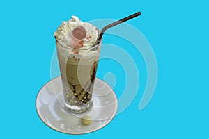 Iced coffee with cream and almonds on light blue background
