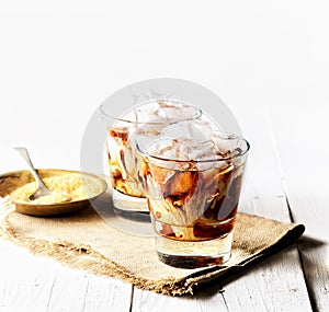 Iced coffee and cream, napkin, brown sugar on a white background