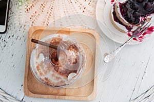 Iced coffee and delicious blueberries cake on vintage style table. Top view