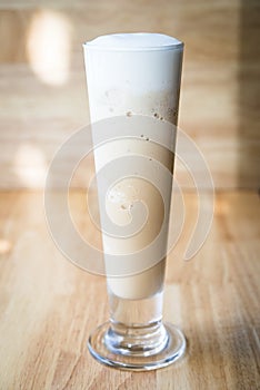 Iced coffee frappe on a wooding table with a wood background