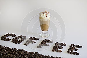 Iced coffee or Frappuccino with whipped cream and syrup .Coffee word , text made of roasted coffee beans isolated on white