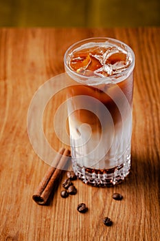 Iced coffee with ice. Frappe, frappuccino with cream and cinnamon on wooden table. copy space
