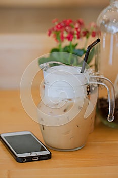 Iced coffee Latte brown in glass mug jar on wooden table from coffee shop.