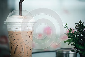 Iced coffee latte decoration with milk froth in plastic glass