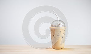 Iced coffee or coffee latte in takeaway cup on wooden table. coffee package for takeaway.