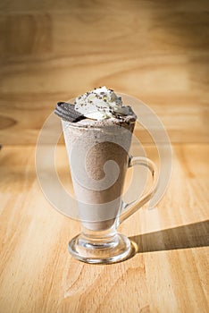 Iced coffee milkshake on a woodon table with a wood background