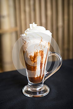 Iced coffee milkshake on a woodon table with a wood background