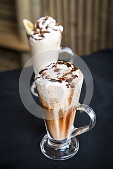 Iced coffee milkshake on a woodon table with a wood background