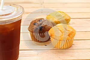 iced coffee with muffins on wooden table