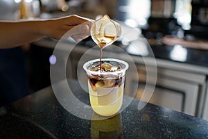 Iced coffee with orange - A plastic glass of americano mixed with craft soda and yuzu orange juice.