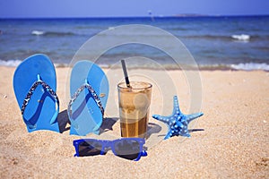 Iced coffee on a sandy beach