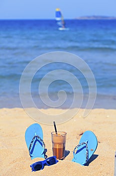 Iced coffee on a sandy beach