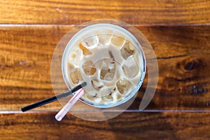 Iced coffee in takeaway cup on dark wood sucupira photo