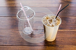 Iced coffee in takeaway cup on dark wood sucupira photo