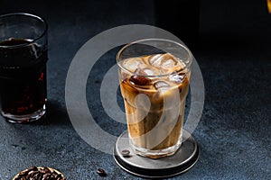 Iced coffee in a tall glass with cream poured over. Iced latte. Cold summer drink. Cold brew in glass. Cappuccino on Ice