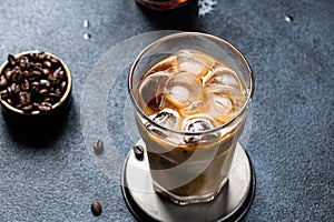 Iced coffee in a tall glass with cream poured over. Iced latte. Cold summer drink. Cold brew in glass. Cappuccino on Ice