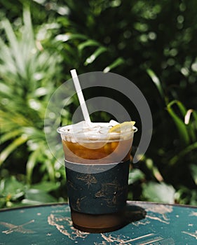 Iced cold brew coffee with lemon on a table