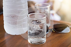 Iced cold fresh water on the table with hot summer sunlight.