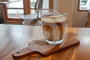 Iced dirty coffee menu served in glass on wooden table in cafe