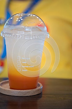 Iced drink syrup orange mix with soda in a plastic cup