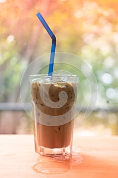 Iced Espresso coffee in a tall glass on wooden table