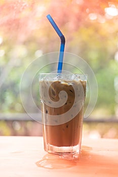 Iced Espresso coffee in a tall glass on wooden table