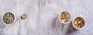 Iced green japanese hojicha tea in cups and leaves in a bowl top view web banner