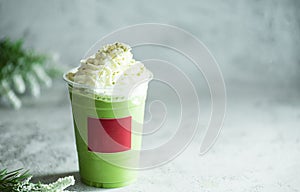 Iced green matcha latte tea and milk in glass on stone table background. Traditional japanese drink and beverage concept