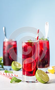 Iced hibiscus tea karkade, red sorrel, Agua de flor de Jamaica or lemonade with raspberries, blackberries, mint and citrus.