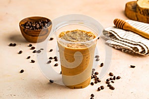 Iced Latte with coffee beans served in cup isolated on wooden board top view cafe drink
