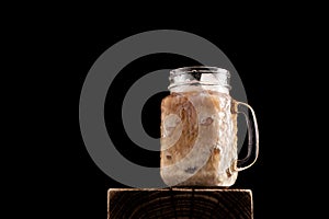 Iced latte coffee in cup glass on black background. Close-up, copy space