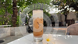 iced latte coffee in glass Delicious ice latte coffee on a seaside in summer. Cold drink at beach cafe outdoors. Travel