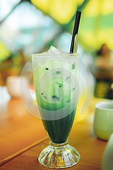 Iced matcha green tea latte with Milk in tall glass.