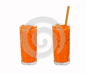 Iced milk tea color orange with crushed ice in glass on tall square shape fragrant sweet with straw isolated on white background.