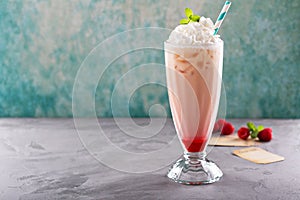 Iced milkshake with raspberry syrup and whipped cream