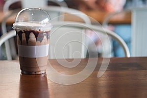 Iced mocha coffee with condensed milk and chocolate sauce in a plastic glass