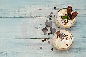 Iced Mocha Frappe Coffee with Whip Cream, Summer Drinking times. Coffee Beans. rustic textured Wooden Background. Mint Leaves Copy
