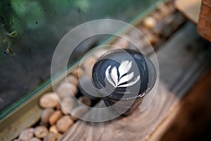 Iced mocha - A glass of coffee latte mixed with black cocoa on wooden table.